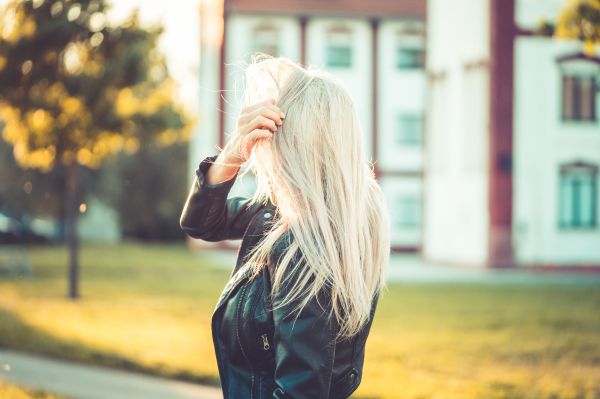 Blonde Woman Playing with Hair Against Sun Free Photo