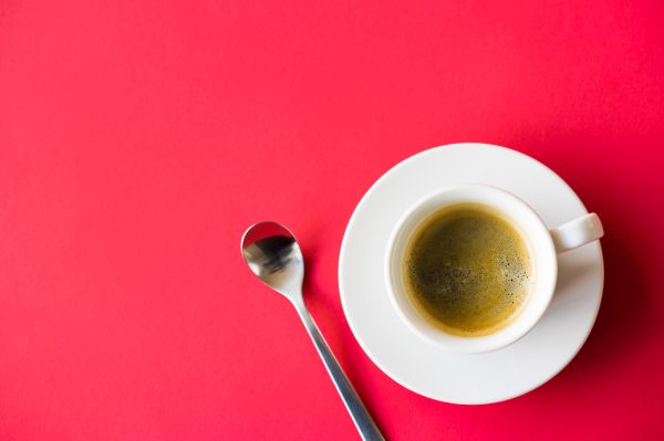 Cup of Coffee on Red Background Space for Text Free Photo