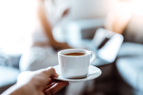 Holding a Cup of Coffee in the Office for Colleague Free Photo