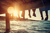 Family sitting on pier by the sea