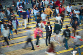 Businessman using smart phone amidst crowd