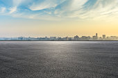 City skyline and buildings with empty asphalt road at sunrise