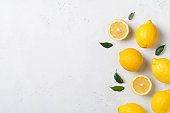 Ripe lemons flat lay with leaves on white background