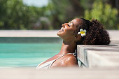 Beautiful african woman in pool relaxing