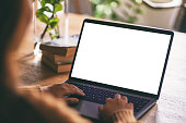 a woman using and typing on laptop with blank white desktop screen