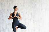 Brunette woman yoga instructor doing vrikshasana