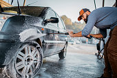 Handsome man washing car