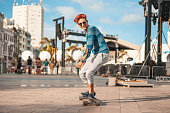 Young skateboarder with a long board in Marco Zero, Recife, Pernambuco.