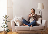 Young coffee lover sniffing hot drink at cozy home interior