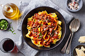 Pasta fettuccine with beef ragout sauce in black bowl. Grey background. Close up. Top view.