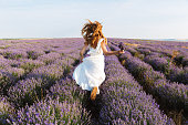 Back view of a pretty young girl in dress running