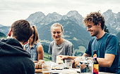 Group of young adults eating outside on a picnic table