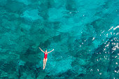 Woman floating turquoise sea