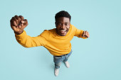 Top view of cheerful black guy gesturing on blue