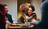 Two Friends Hugging During A Dinner Celebration