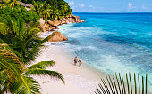 Anse Source d'Argent, La Digue Seychelles, young couple men and woman on a tropical beach during a luxury vacation in the Seychelles. Tropical beach Anse Source d'Argent, La Digue Seychelles