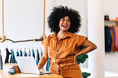 Ethnic small business owner smiling cheerfully in her shop