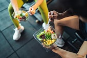 Top view Asian man and woman healthy eating salad after exercise at fitness gym.