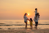 Happy asian family that enjoys beach activities during the summer holidays. parent and children enjoy the sunset sea on beach.Holiday travel concept, Summer vacations.