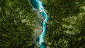 Scenic aerial view of the mountain landscape with a forest and the crystal blue river in Jotunheimen National Park