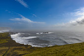 Storm clouds over Dyrholaey black basalt sand beach