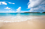 Perfect conditions with bright blue ocean and white sand beach on a sunny day