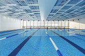 Close-up View Of Olympic Swimming Pool With Cityscape Through The Window