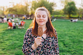 Happy young woman with delicious chocolate ice cream outdoors. Unhealhty food and weight loss concept. Summer time, eating