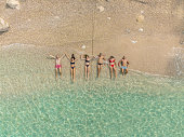 Bird's-eye view of friends lying on beach