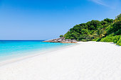 Empty tropical beach of Similan islands with white sand, clear water and greenery.