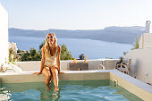 Woman relaxing and sunbathing by the pool, 