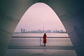 Captivating dusk: Woman admiring Dubai skyline from Creek Harbour