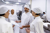 Boss talking to a group of bakers at a food processing plant