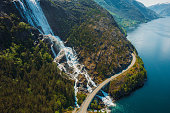 Aerial View of Idyllic Mountain Road Above Scenic Waterfall in Norway