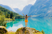 Woman Tourist Admiring Summer with Scenic View of Lake Lovatnet in Norway