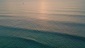 Majestic ocean surface rippling under evening sunlight aerial. Golden sunset