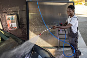 Worker Washing Car at Outdoor Service Station