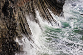 Basalt columns and the rugged coastline of Arnarstapi in the Snaefellsnes Peninsula, western Iceland. Close up detail of the crashing waves along the cliff.