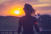 Woman admiring sunset from her balcony