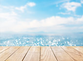 Wooden table top on blue sea and white sand beach