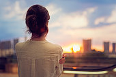 Young girl is watching sunset over Tokyo