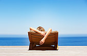 Rear view of woman reclining on folding chair outdoors