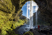 Hiker at Majestic Kvernufoss Waterfall in Iceland