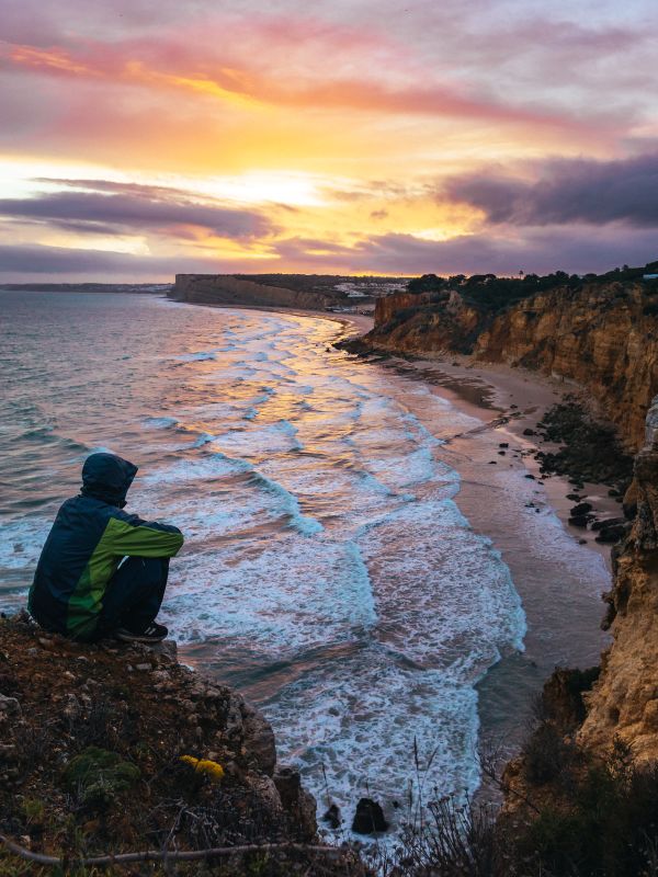 Man Enjoying Cloudy Sunset by Portugal Coastline Free Photo