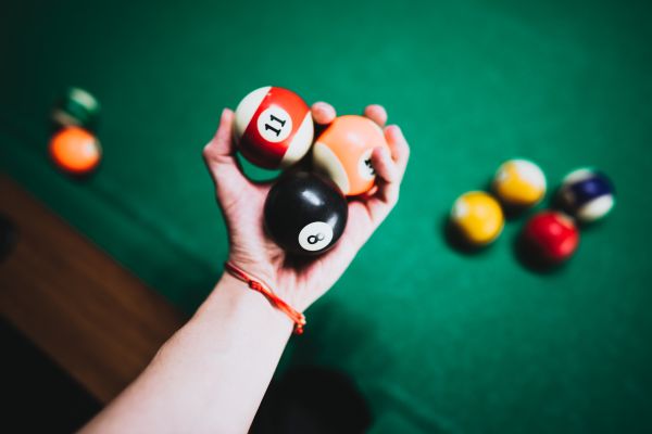 Man Holding Vintage Billiard Balls in His Hand Free Photo