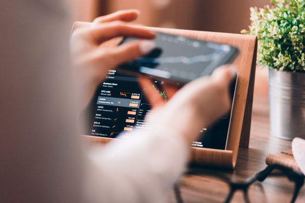 Woman Analyzing Stock Charts via Smartphone at Home Free Photo