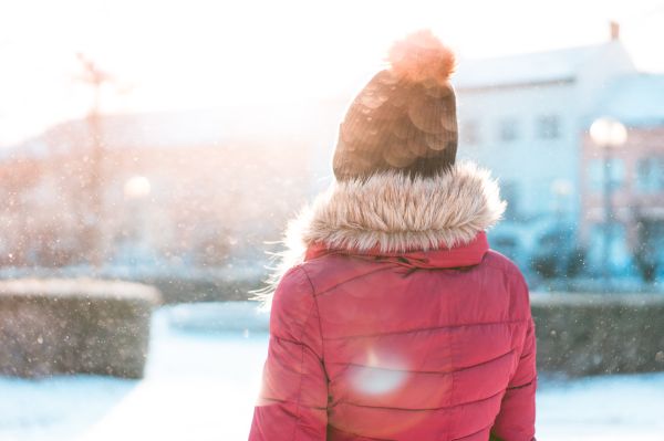 Woman Standing in Snowfall while Sun is Shining Free Photo