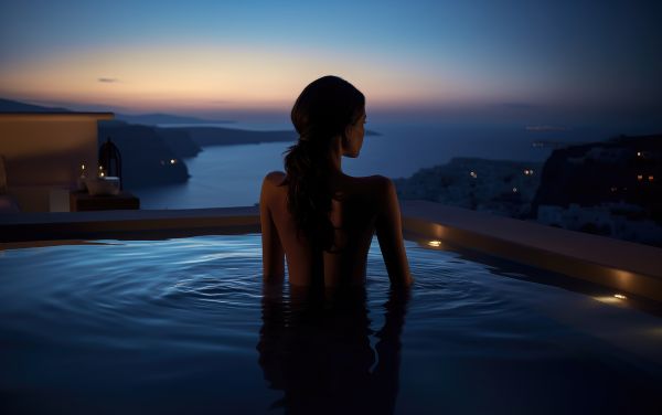 Woman Swimming in a Luxury Santorini Hotel Pool After Sunset Free Image