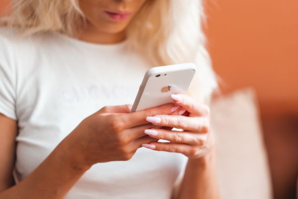 Young Blonde Woman Using White Smartphone Free Photo