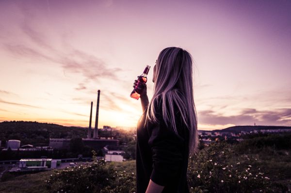 Young Woman Enjoying a Drink in Sunset Free Photo